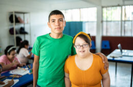 Portrait of disabled students embracing in the classroom at school