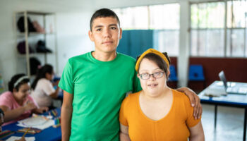 Portrait of disabled students embracing in the classroom at school