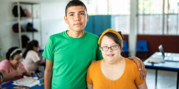 Portrait of disabled students embracing in the classroom at school